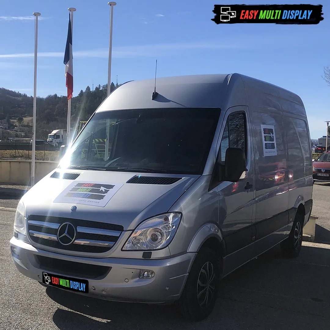 Furgón de puesto de mando móvil Easy Multi Display, rotulado Mobile Command Center, ante una bandera francesa