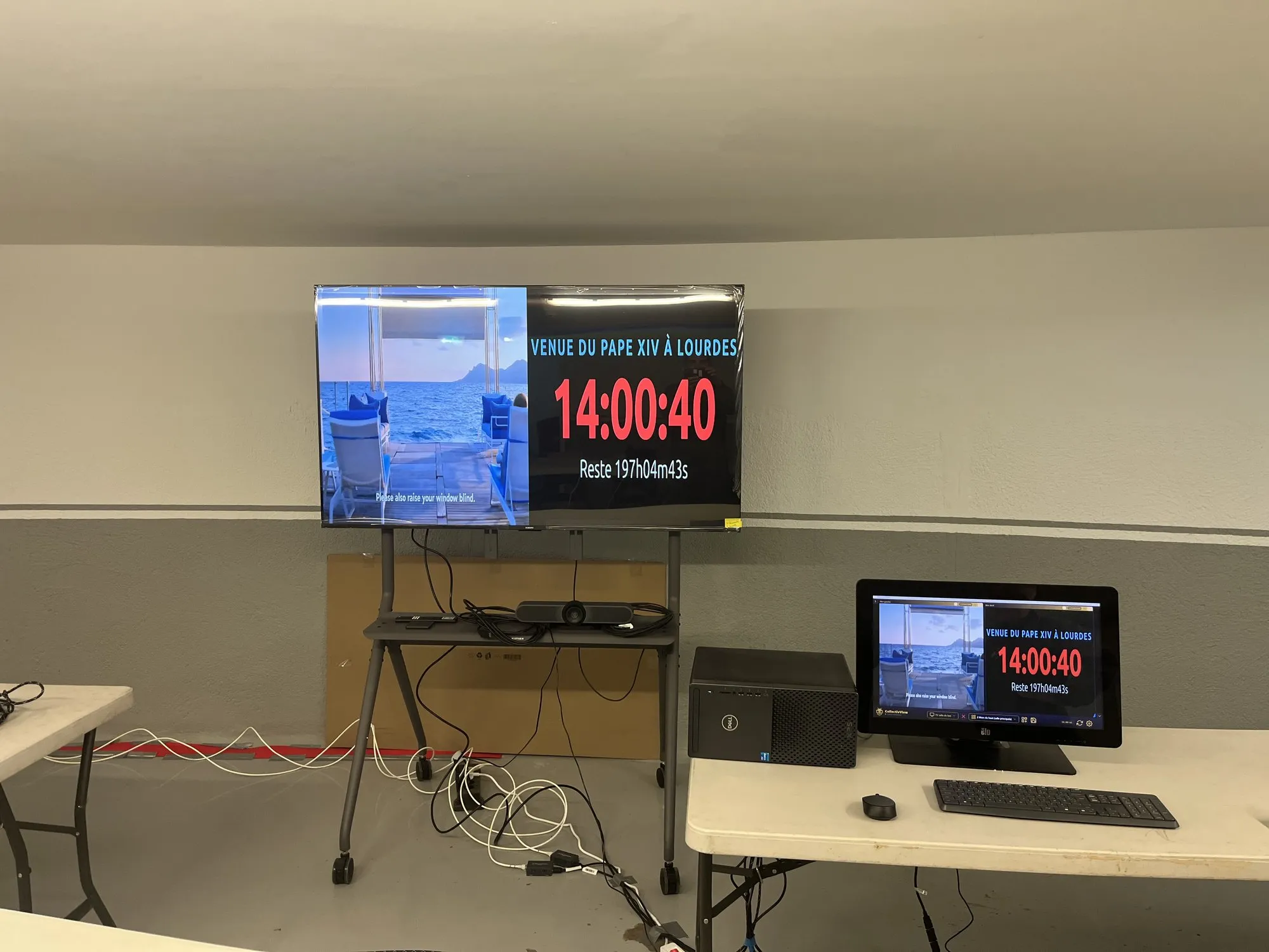 Une salle satellite : grand écran et poste de pilotage affichant le compte à rebours de la visite