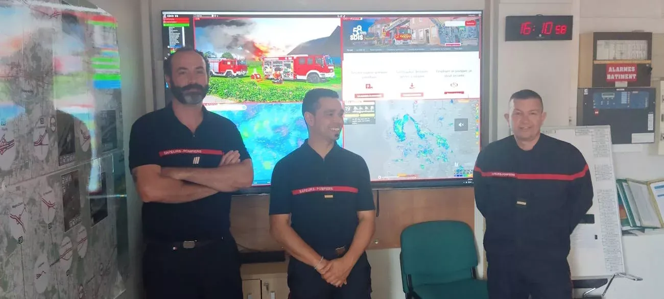 Sapeurs-pompiers en salle opérationnelle devant le mur d'images, SDIS 58